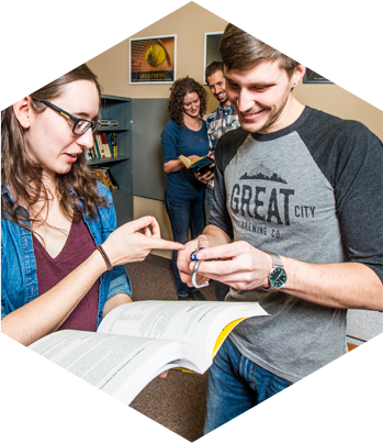 Inspecting the books for clues in The Office Escape Room